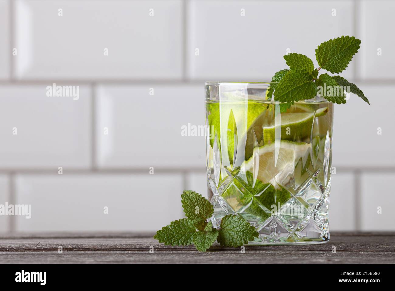 Cocktail Caipirinha originale in piedi sul lato destro dell'immagine. Spazio libero per il testo. Gustoso cocktail con menta, rum, lime, zucchero e ghiaccio. Foto Stock