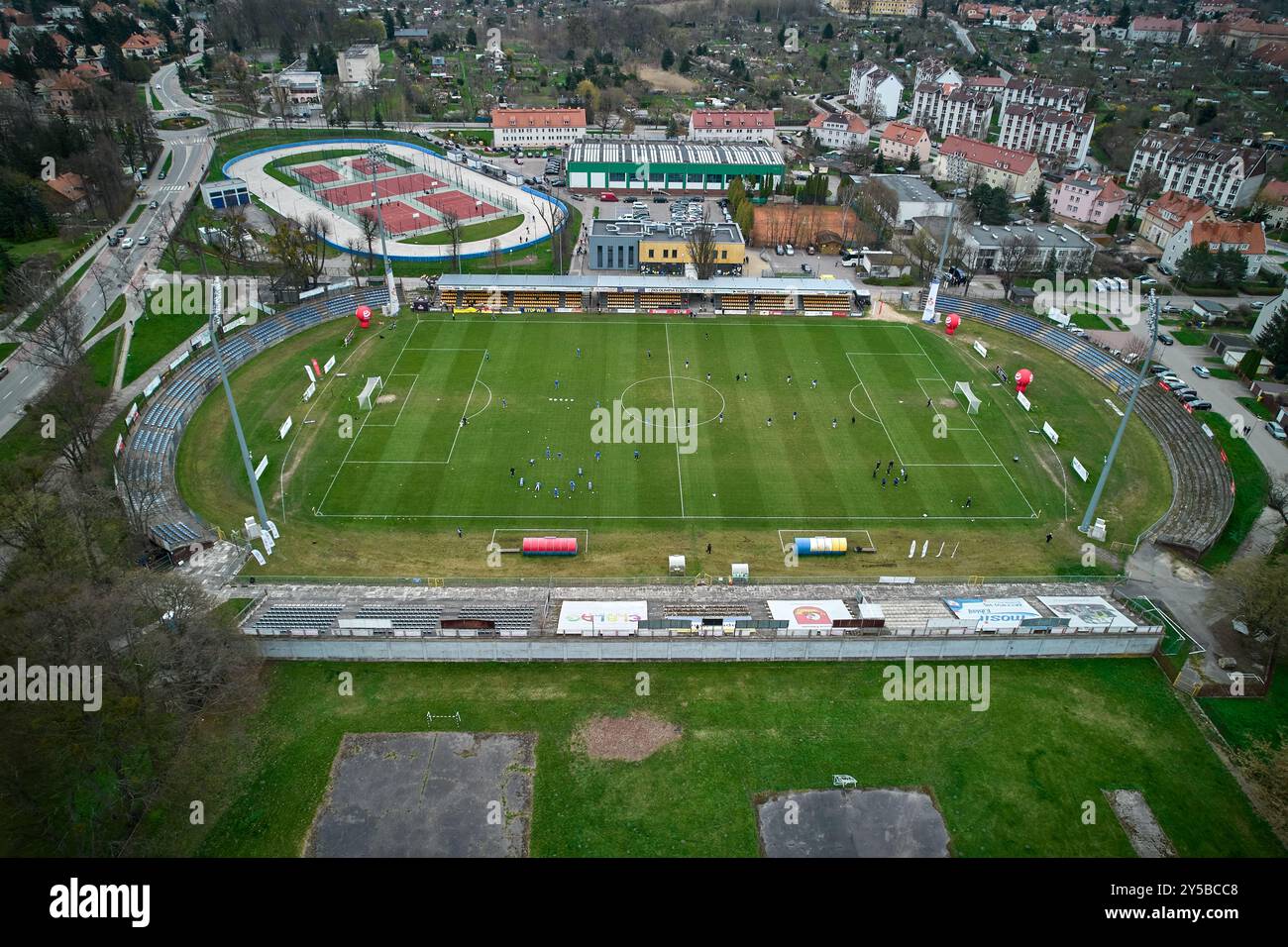 Vista aerea dello stadio municipale di Elbląg circondato da edifici residenziali e aree verdi in una giornata nuvolosa Foto Stock