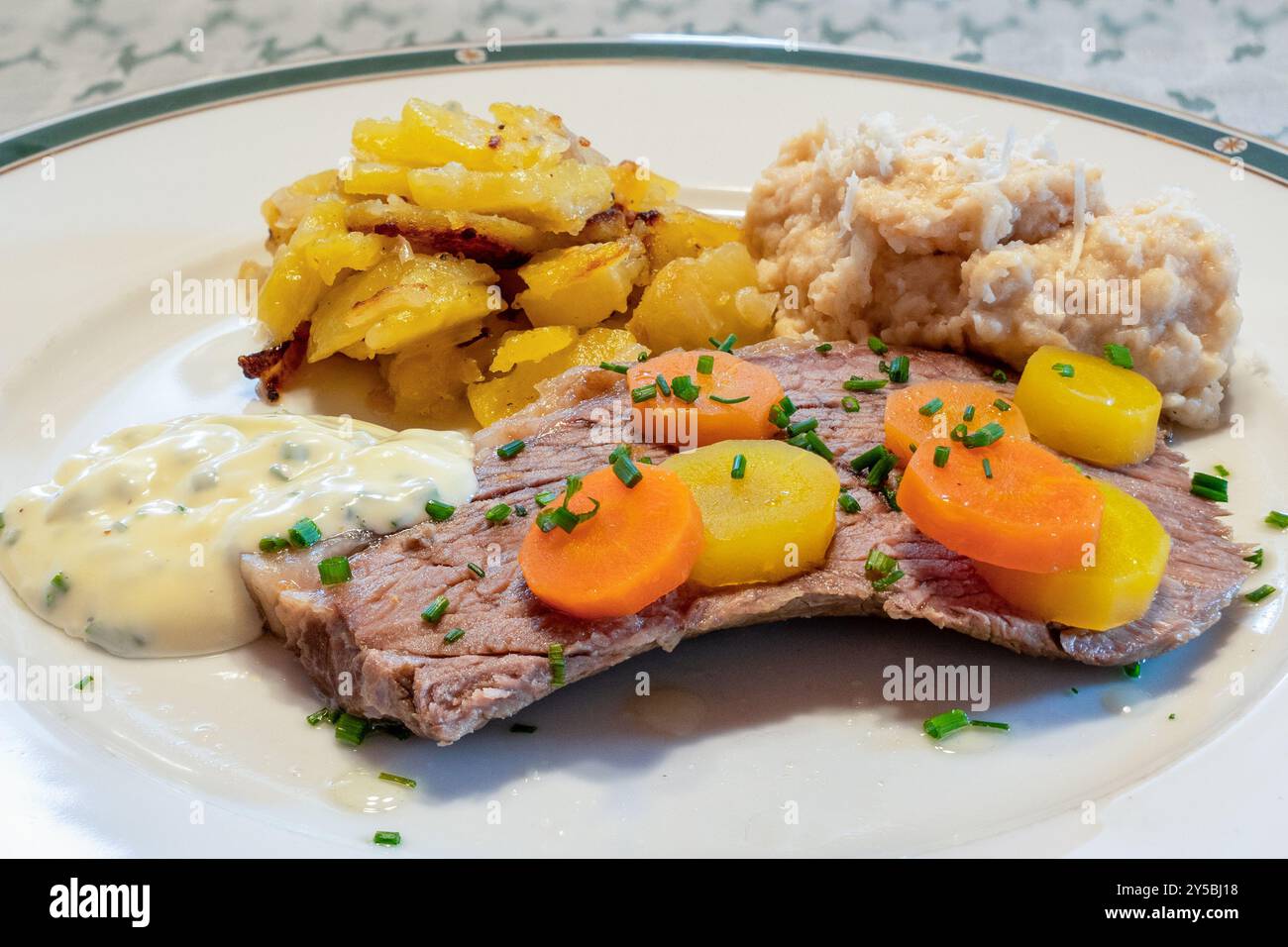 Tafelspitz di manzo bollito di prima qualità viennese con contorni tradizionali di salsa di erba cipollina, patate viennesi, rafano di pane e carote Foto Stock