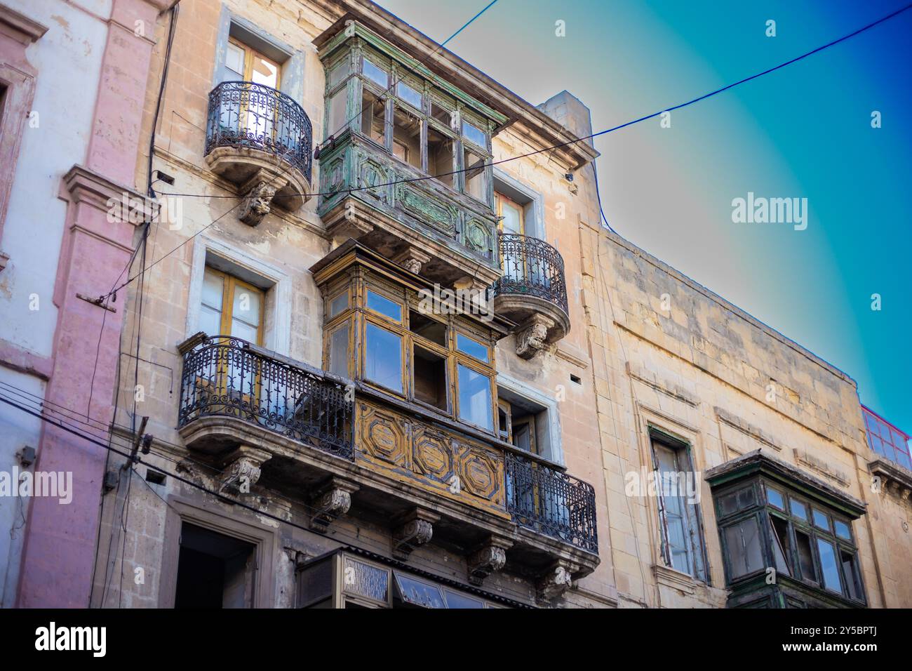 Vecchio edificio in rovina con porte chiuse in legno a la Valletta, Malta Foto Stock