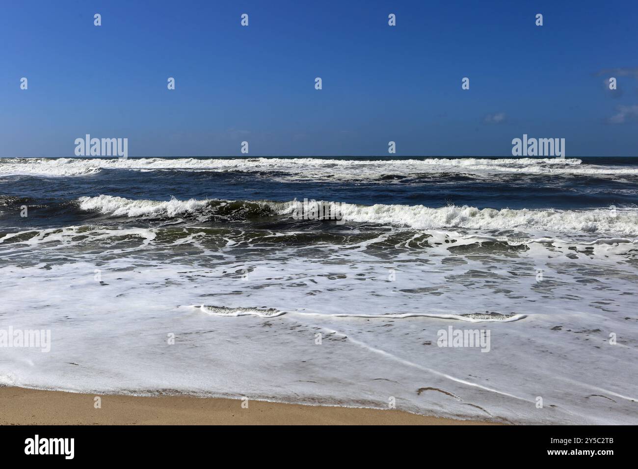 Espinho, Portogallo - 26 marzo 2023: Una tranquilla scena dell'Oceano Atlantico lungo la costa del Portogallo, con le onde che si infrangono contro una barriera rocciosa Foto Stock