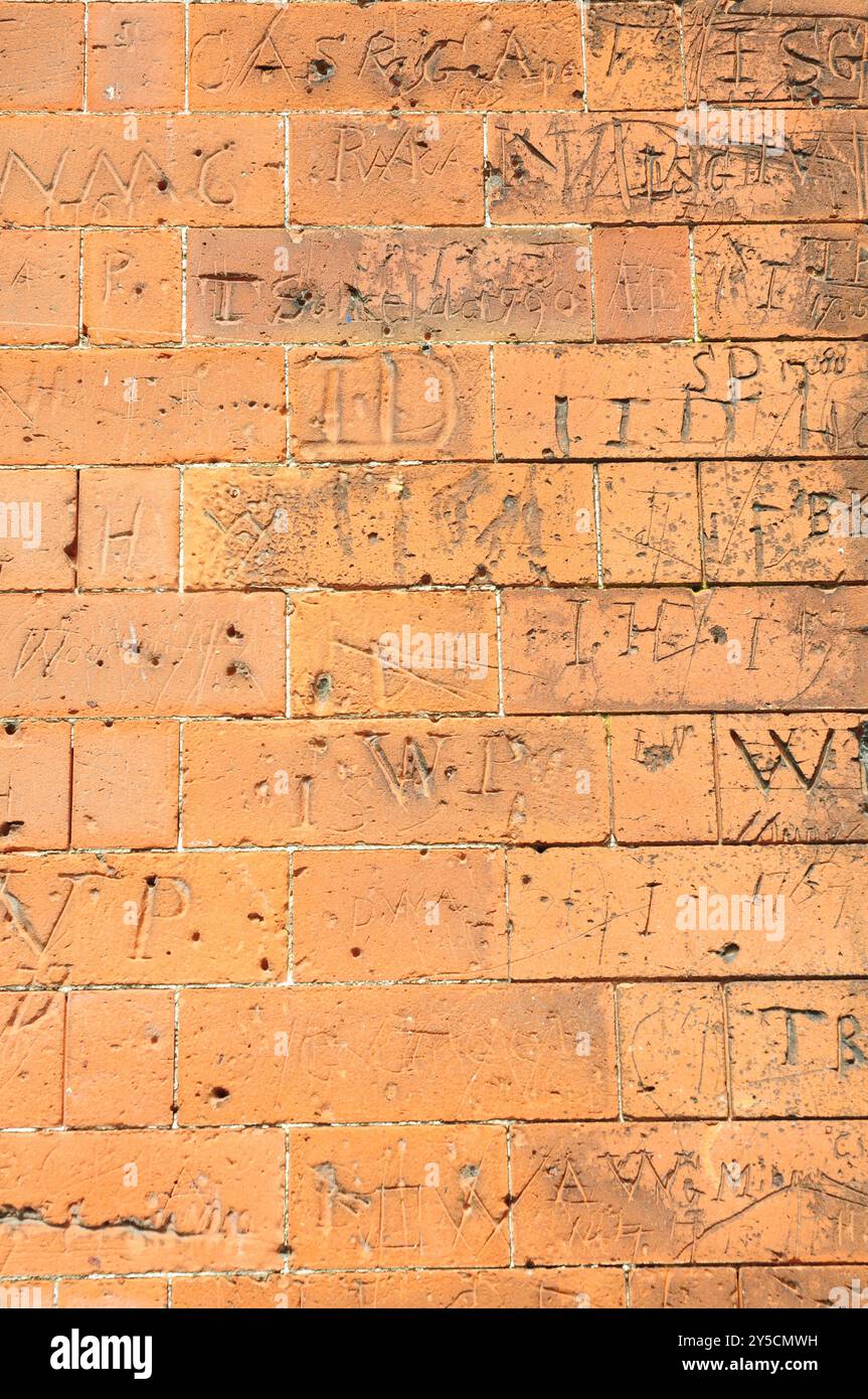 Nomi e iniziali dei bambini graffiati sui mattoni della scuola, Dedham. Foto Stock