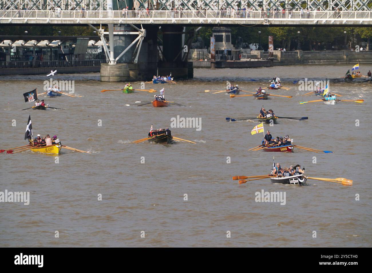 Le barche passano sotto il Westminster Bridge nel centro di Londra, partecipando alla Great River Race, che riunisce fino a 300 barche e 1500 persone che regnano da Millwall a East London a Richmond, per raccogliere fondi per organizzazioni di beneficenza. Ogni anno, le barche in stile tradizionale corrono l'una sull'altra lungo il percorso di 21,6 km, con molti concorrenti provenienti da tutto il mondo. Data foto: Sabato 21 settembre 2024. Foto Stock