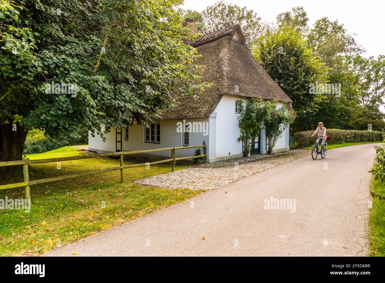 In bicicletta nella regione di Angeln vicino a Kappeln an der Schlei. Cottage con tetto di paglia a Rabenkirchenholz, Rabenkirchen-Faulück, Schleswig-Holstein, Germania Foto Stock