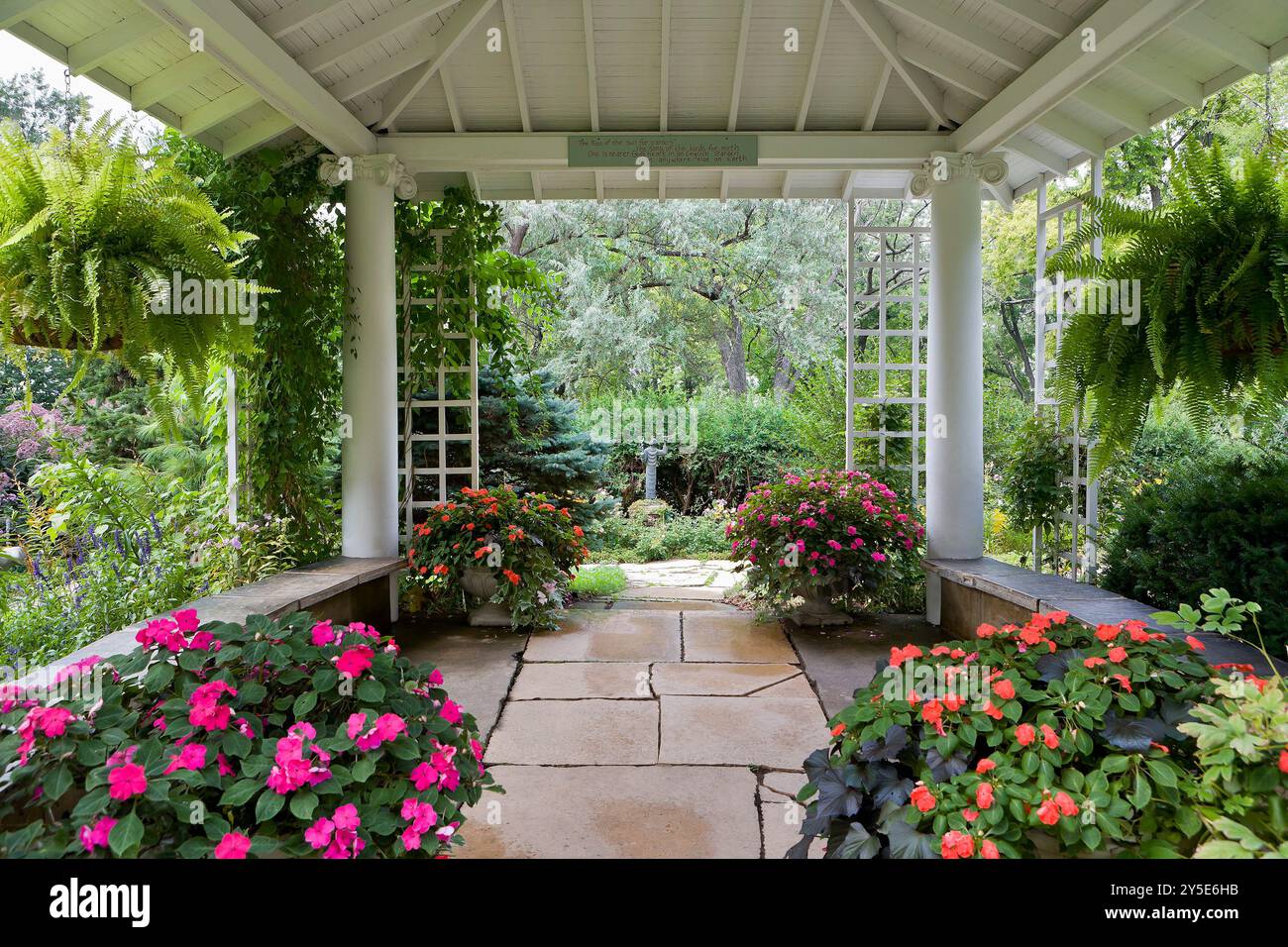 Gazebo in giardino all'inglese con una profusione di fiori Foto Stock