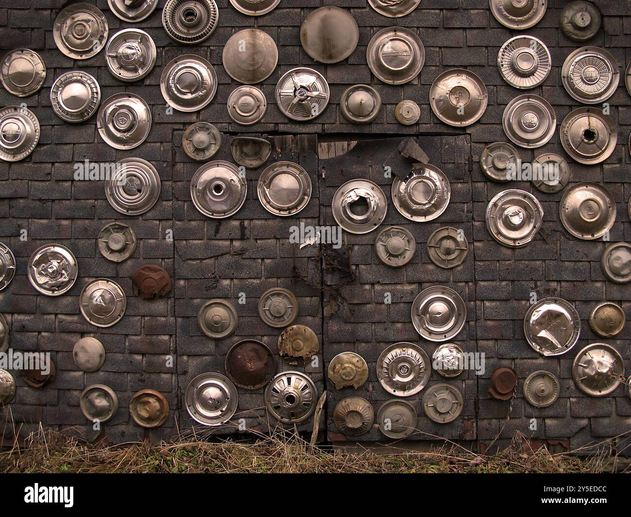 Vecchi coprimozzo di auto su un muro nella parte settentrionale dello stato di New York Foto Stock