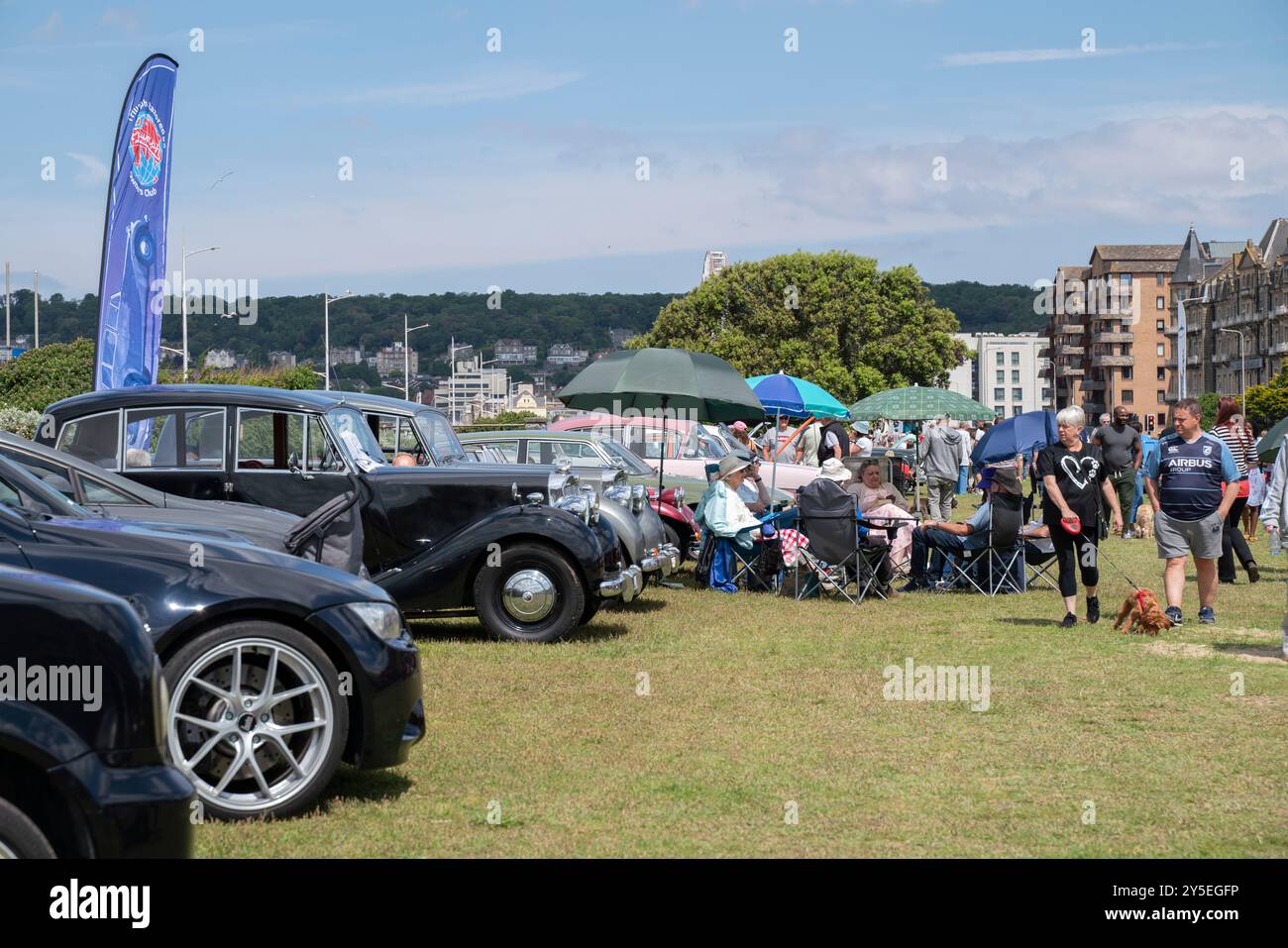 La gente partecipa a una mostra di auto sui prati della spiaggia di Weston-super-Mare, nel Somerset settentrionale, in una giornata di sole d'estate. Foto Stock