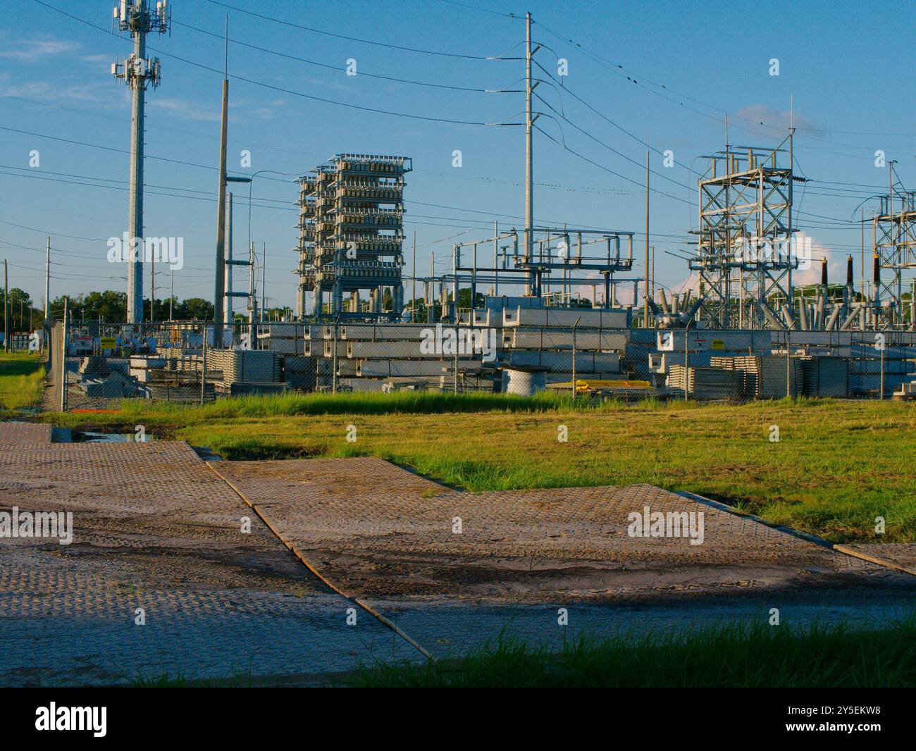 Tappetini di accesso stradali provvisori per lavori edili con visuale ad angolo basso sull'erba per la protezione da carichi pesanti. Ampio colpo su tappetini abbronzanti nel tardo pomeriggio Foto Stock