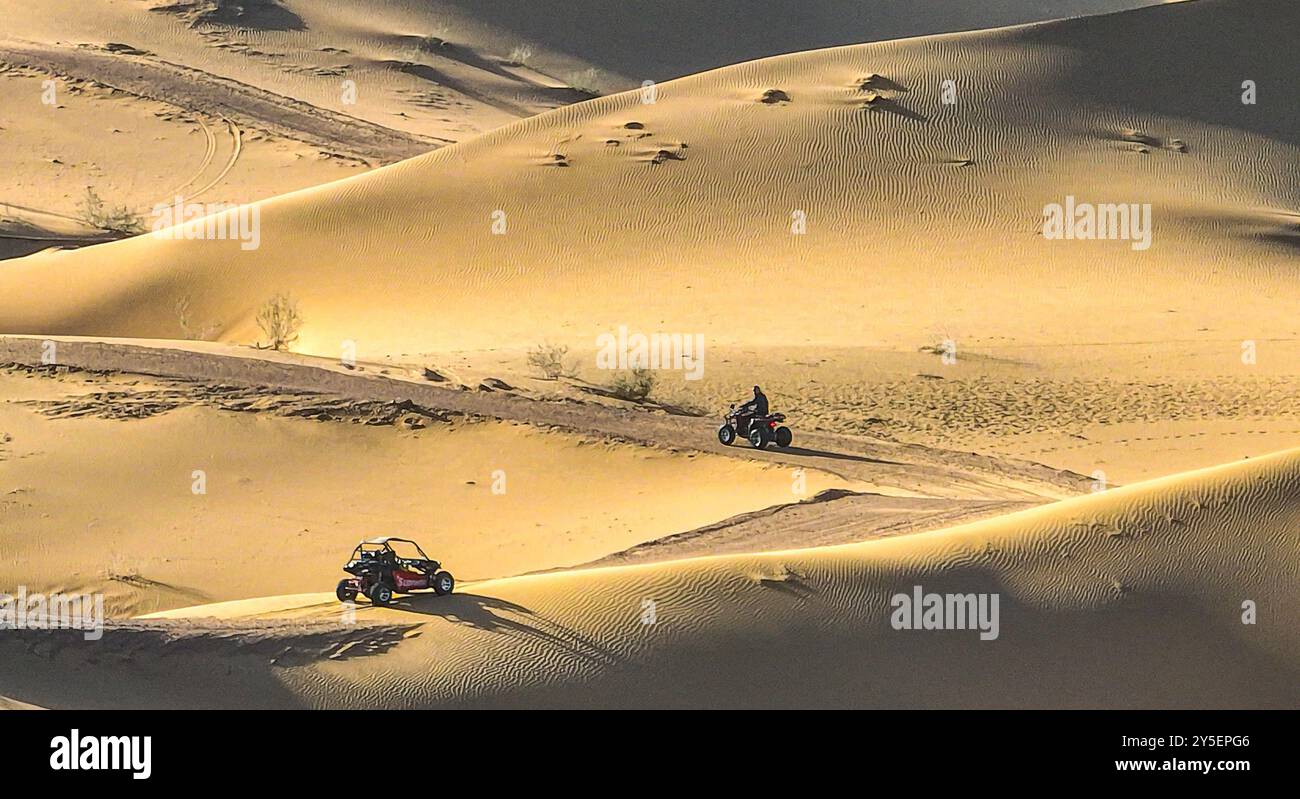 ZHANGYE, CINA - 21 SETTEMBRE 2024 - i turisti guidano motociclette nel deserto di Badain Jaran al campo vacanze Jinshawan Desert Tourism i Foto Stock