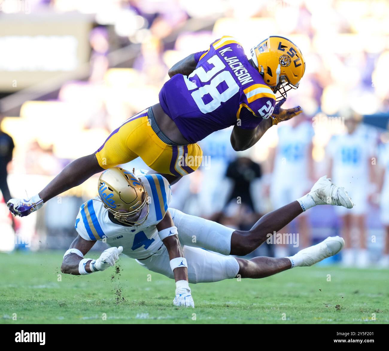 Baton Rouge, Louisiana, Stati Uniti. 21 settembre 2024. Il defensive back dell'UCLA Bryan Addison (4) si abbassò per affrontare il running back della LSU Kaleb Jackson (28) durante una partita di football della NCAA tra i LSU Tigers e gli UCLA Bruins il 21 settembre 2024 a Baton Rouge. LSU ha vinto, 34-17. (Credit Image: © Scott Coleman/ZUMA Press Wire) SOLO PER USO EDITORIALE! Non per USO commerciale! Foto Stock