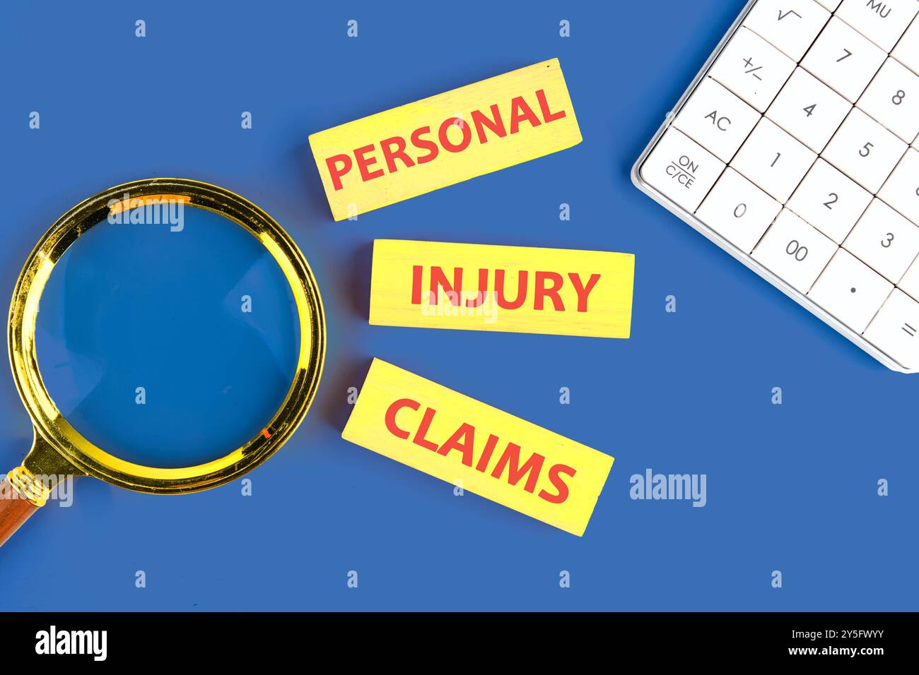 Le parole LESIONI PERSONALI SOSTENGONO che è disposto da blocchi di legno , vista dall'alto in una composizione con una calcolatrice e una lente d'ingrandimento Foto Stock