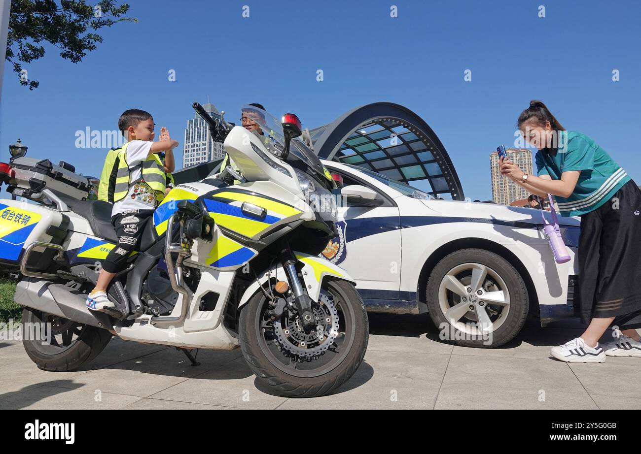 YANTAI, CINA - 21 SETTEMBRE 2024 - Un bambino vive una moto della polizia durante l'Open Day di un campo di polizia nella città di Yantai, nella Cina orientale di Shandong pr Foto Stock
