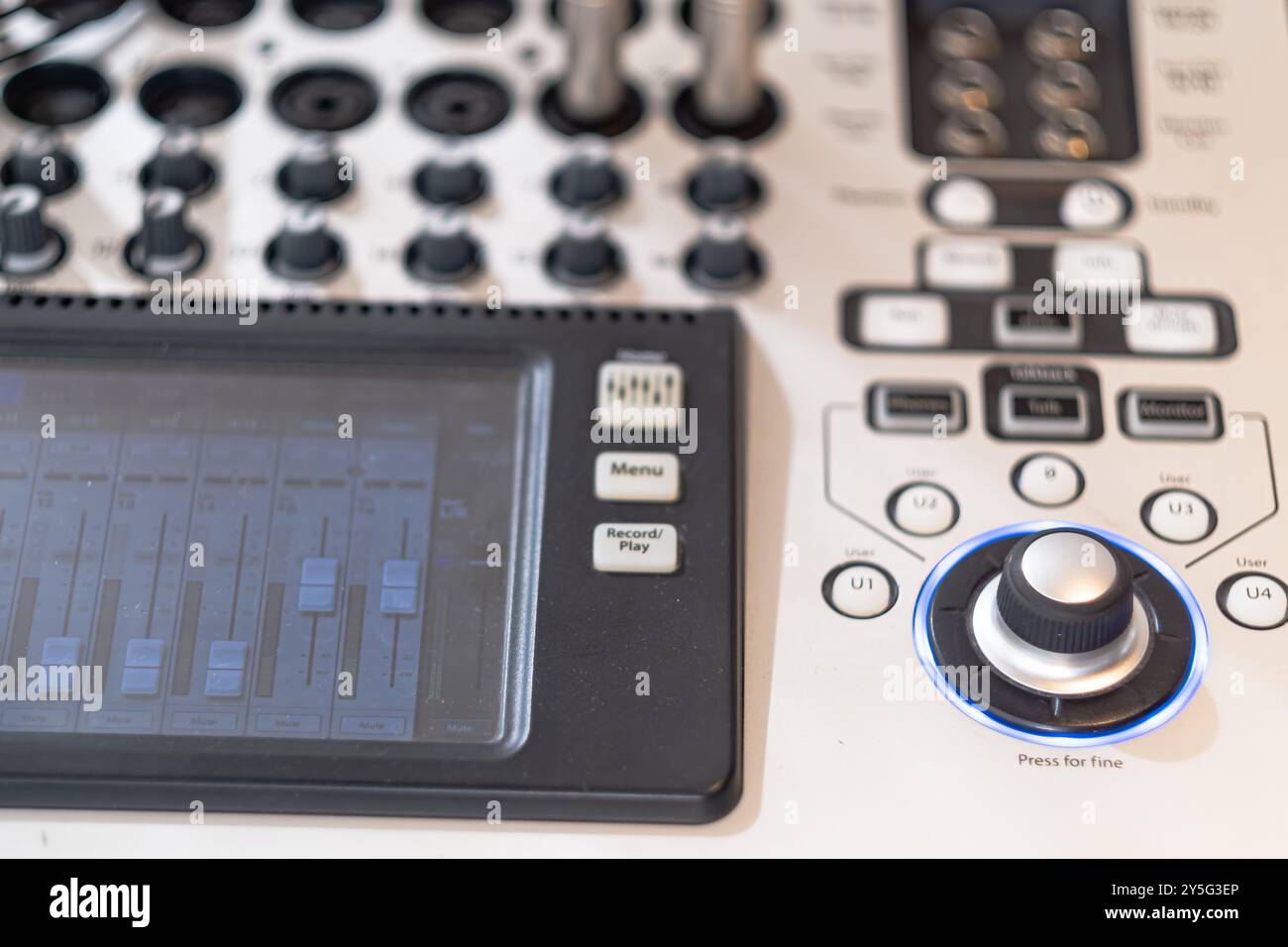 Primo piano di un mixer audio professionale con varie manopole, pulsanti e display digitale. L'immagine mostra gli intricati controlli utilizzati per l'audio Foto Stock