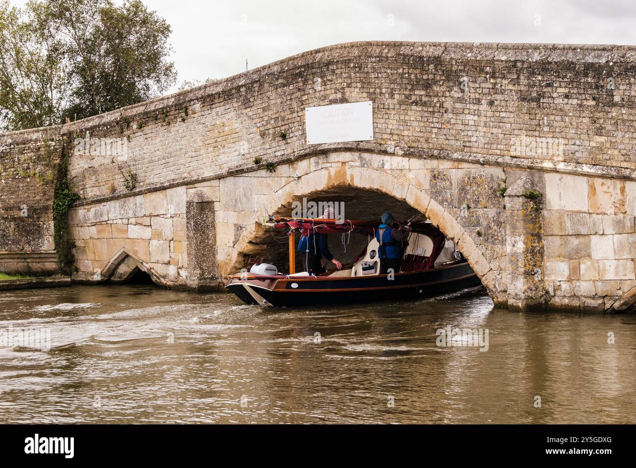 Barca a vela che passa sotto il basso vecchio ponte sul fiume Thurne nel Parco Nazionale di Norfolk Broads. Potter Heigham, Norfolk, East Anglia, Inghilterra, Regno Unito, Foto Stock