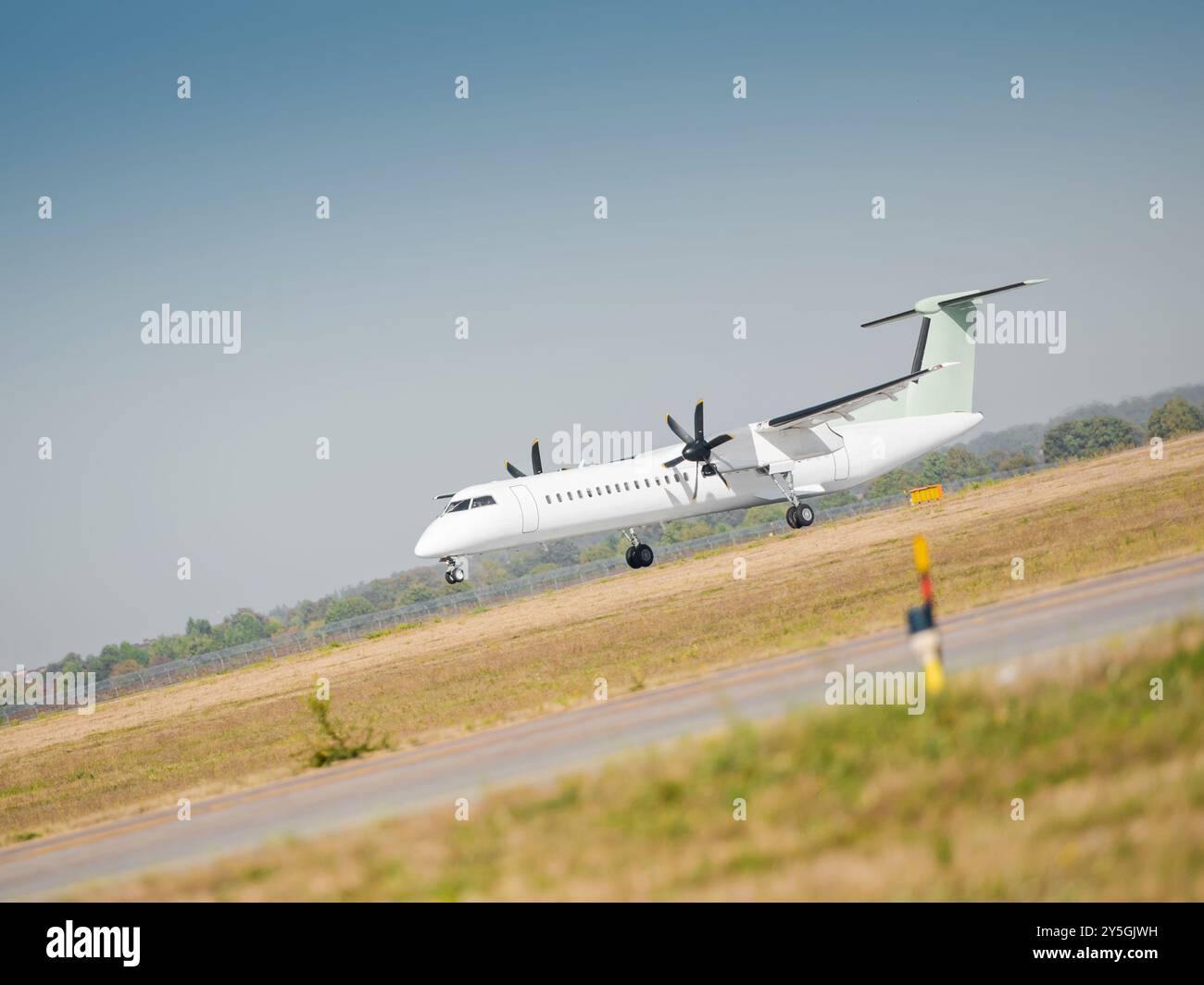 Un aereo turboelica decolla su una pista in una giornata di sole. Un aereo di linea regionale a due motori lascia il suolo e diventa aviotrasportato. Foto Stock