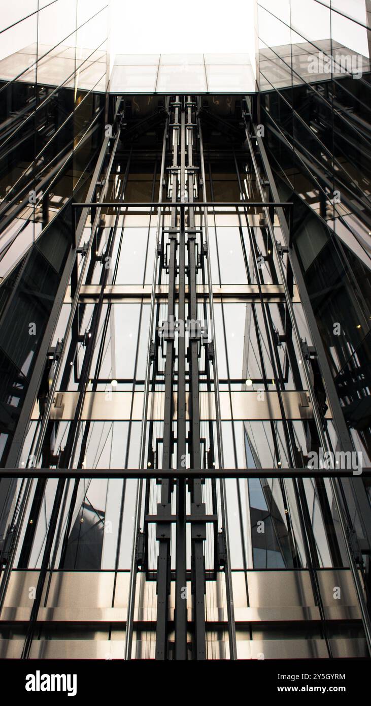 Vista di un ascensore di vetro dal basso nel centro di Londra in un affollato shopping Foto Stock