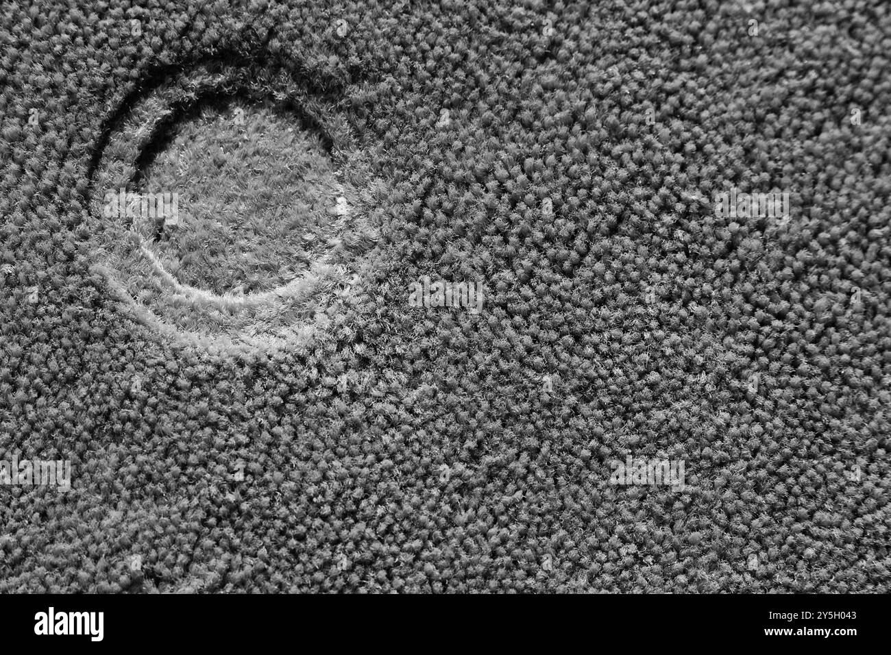 Un'impronta tonda da da gamba di sgabello su tappeto – minimalismo astratto con spazio negativo Foto Stock