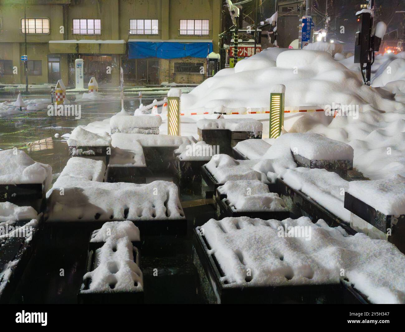 Sentiero di sorgenti termali vulcaniche circondato da nevicate fresche all'esterno della stazione ferroviaria di Shinkansen a Yuzawa, Giappone Foto Stock
