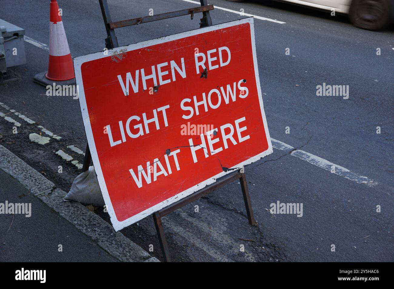 Segnale di stop al semaforo temporaneo. Quando la luce rossa mostra il segnale di avvertimento attendere qui. Foto Stock