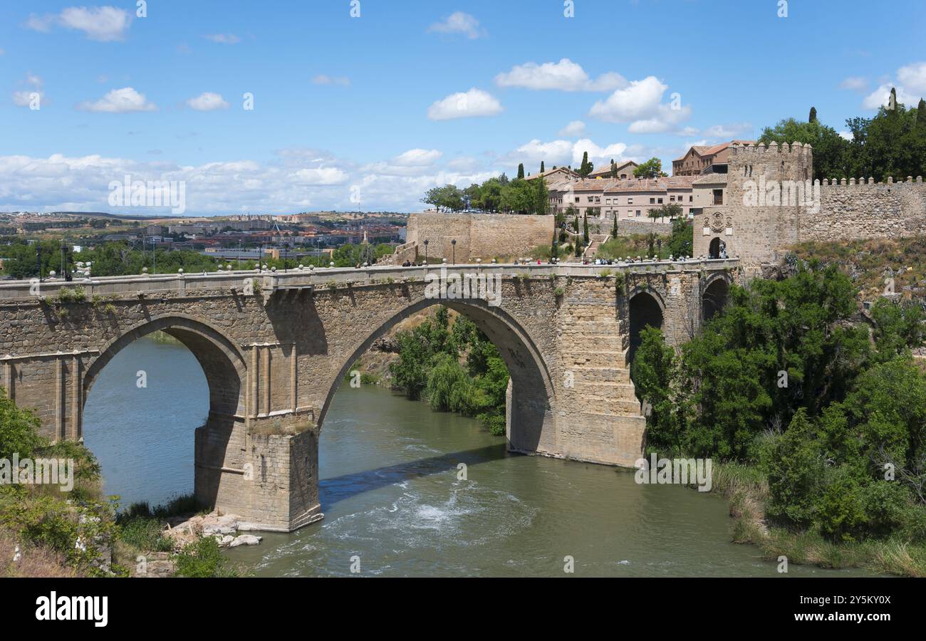 Storico ponte in pietra sul fiume in un ambiente rurale con edifici antichi vicini, Puente de San Martin, Ponte di San Martino, Toledo, fiume Tago, Foto Stock