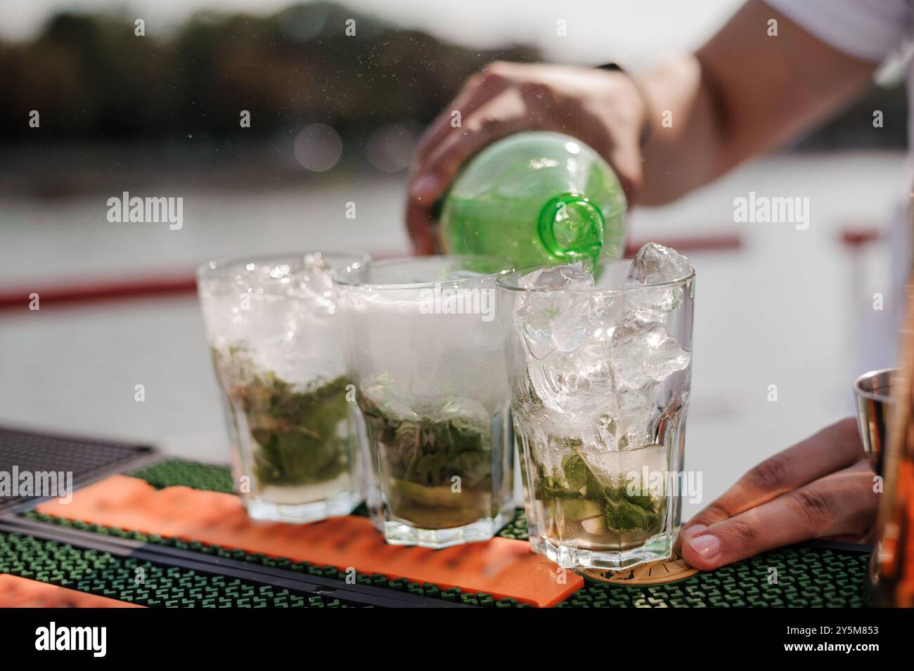 Rinfrescanti cocktail Mojito versati in una giornata di sole sull'acqua. Foto Stock