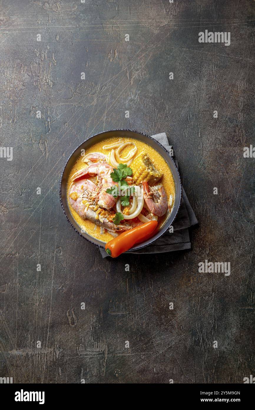 Peruviano zuppa di pesce Chupe de camarones in grigio ciotola, vista dall'alto Foto Stock