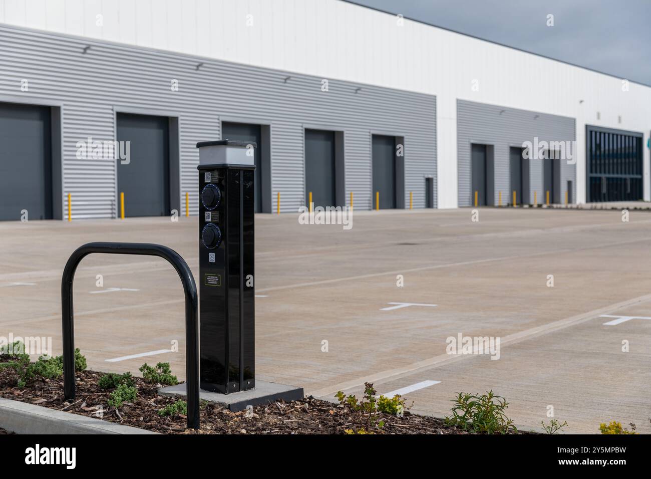 Unità industriali a Havnant Hampshire. Concentratevi su un moderno punto di ricarica EV in primo piano. Foto Stock