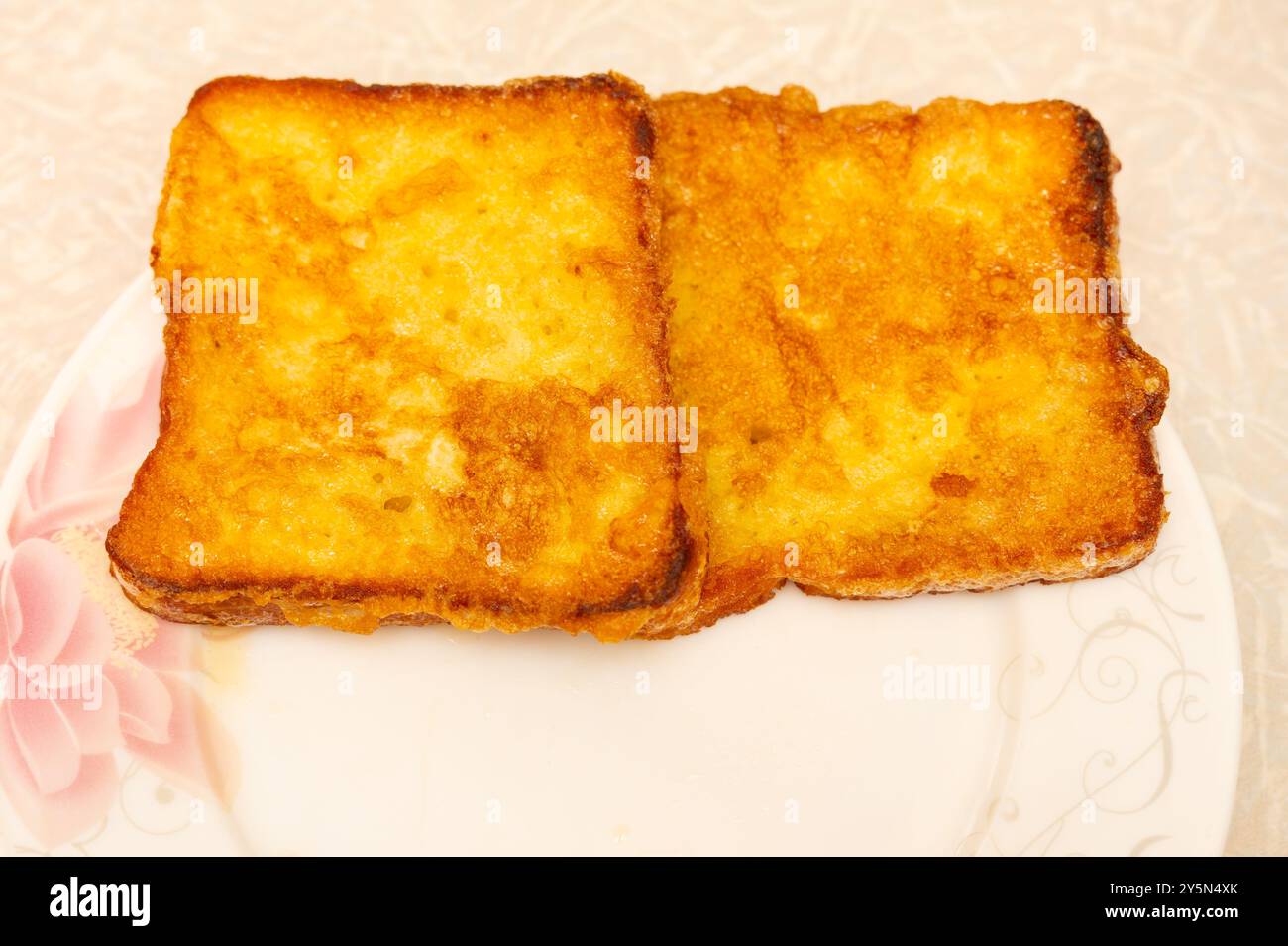 Toast francese dorato su un piatto di fiori. Foto Stock