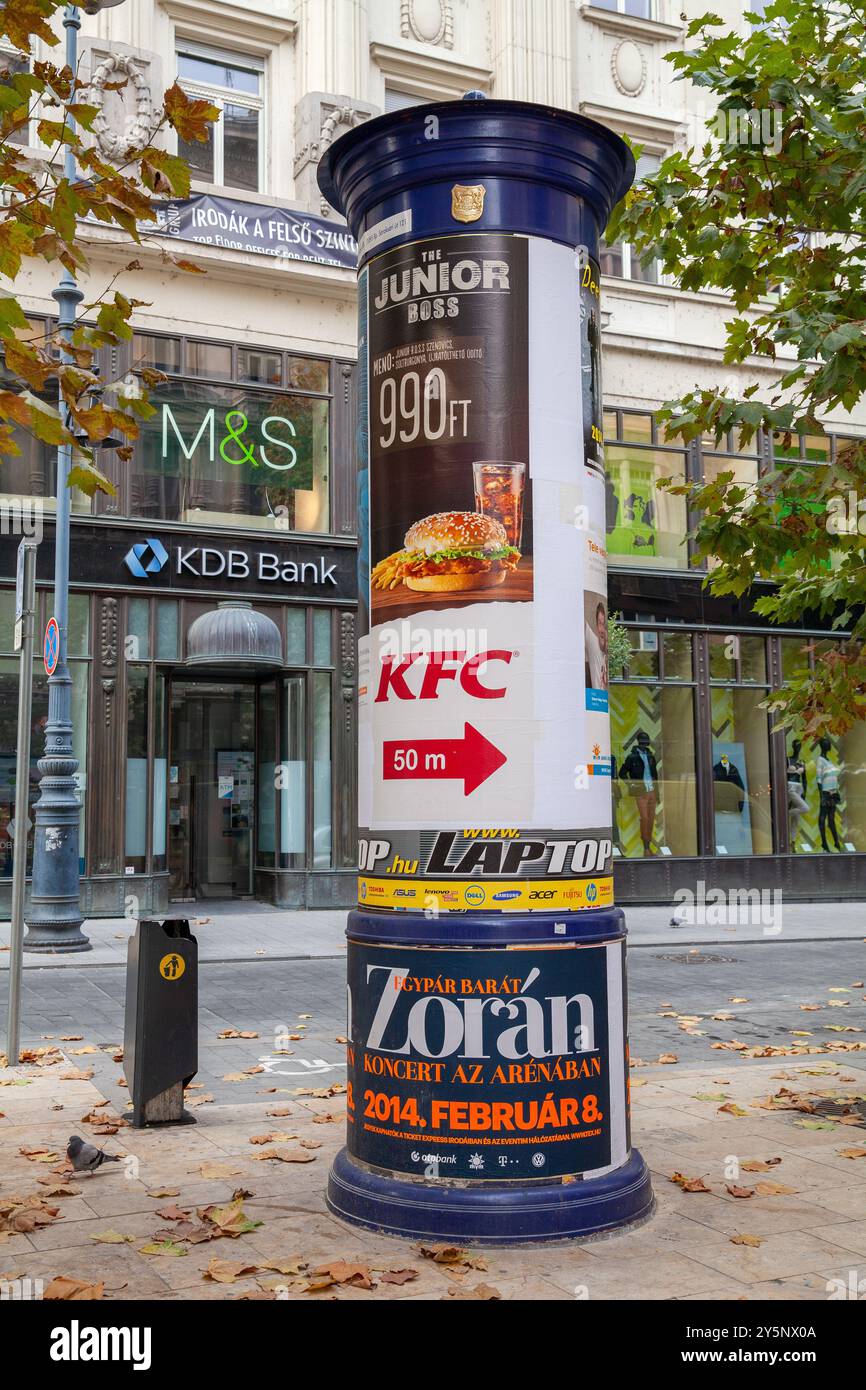 Colonna pubblicitaria Morris Column in via Váci fuori da Duna Plaza, Budapest Ungheria, ristorante ungherese McDonalds pubblicitario Foto Stock