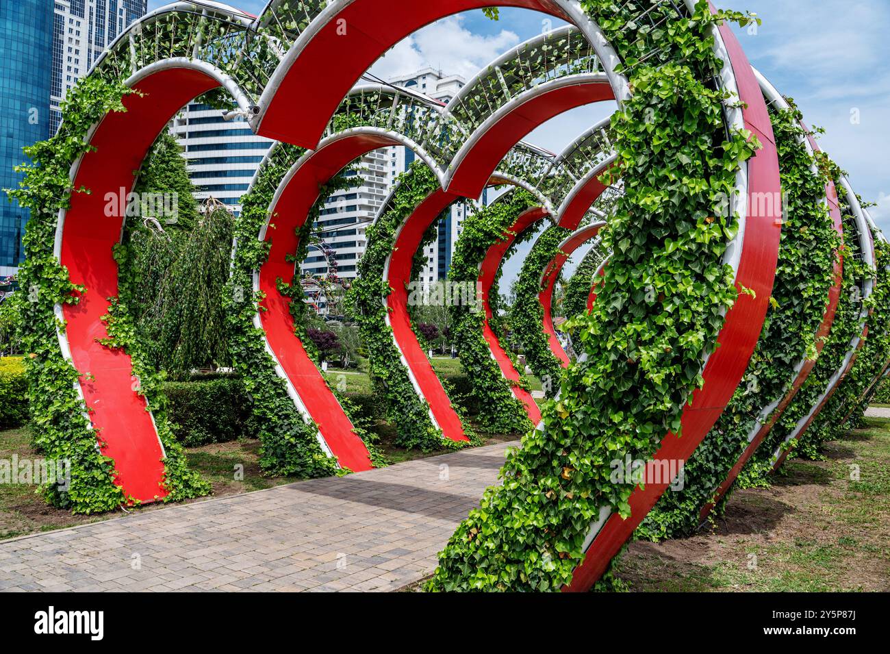 Vista sulla città del parco dei fiori. Arco floreale con giardini di piante di petunia. Un numero enorme di vasi di fiori su supporti metallici. Foto Stock
