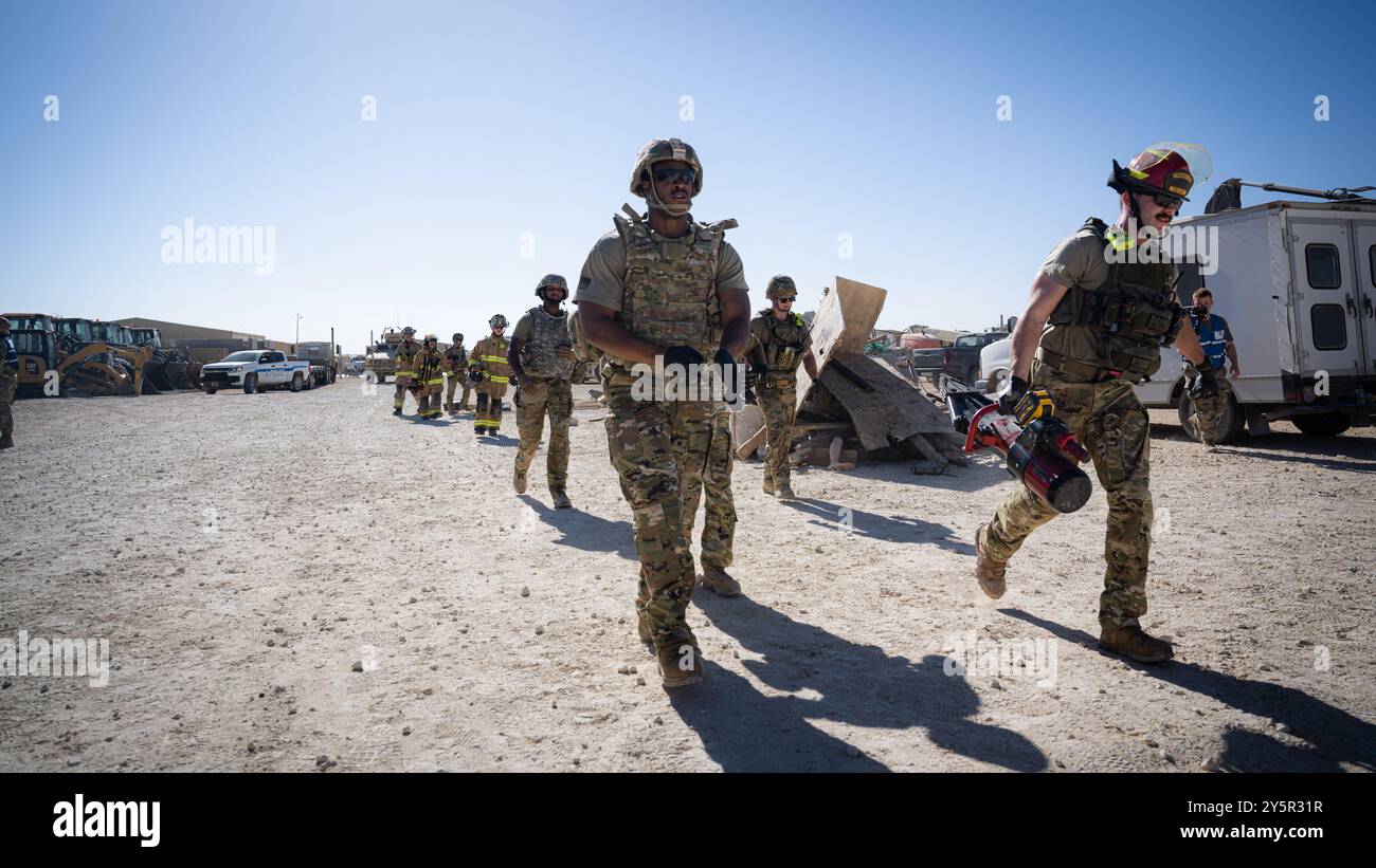 Gli avieri statunitensi assegnati al 332nd Expeditionary Civil Engineer Squadron dei vigili del fuoco si avvicinano alla scena durante un'esercitazione di addestramento per vittime di massa nell'area di responsabilità del comando centrale degli Stati Uniti il 13 settembre 2024. L'esercizio ha messo alla prova varie abilità di cui dispone un soccorritore di emergenza al fine di garantire che siano pronti in caso di crisi reale. (Foto U.S. Air Force) Foto Stock