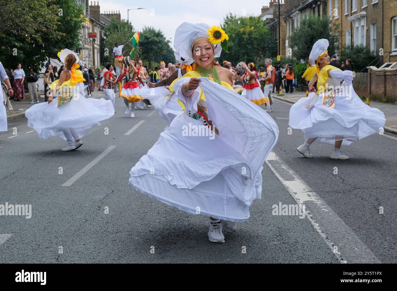 I ballerini in abiti bianchi si esibiscono nel primo carnevale di Hackney in cinque anni. L'evento è stato annullato per una serie di motivi. Foto Stock
