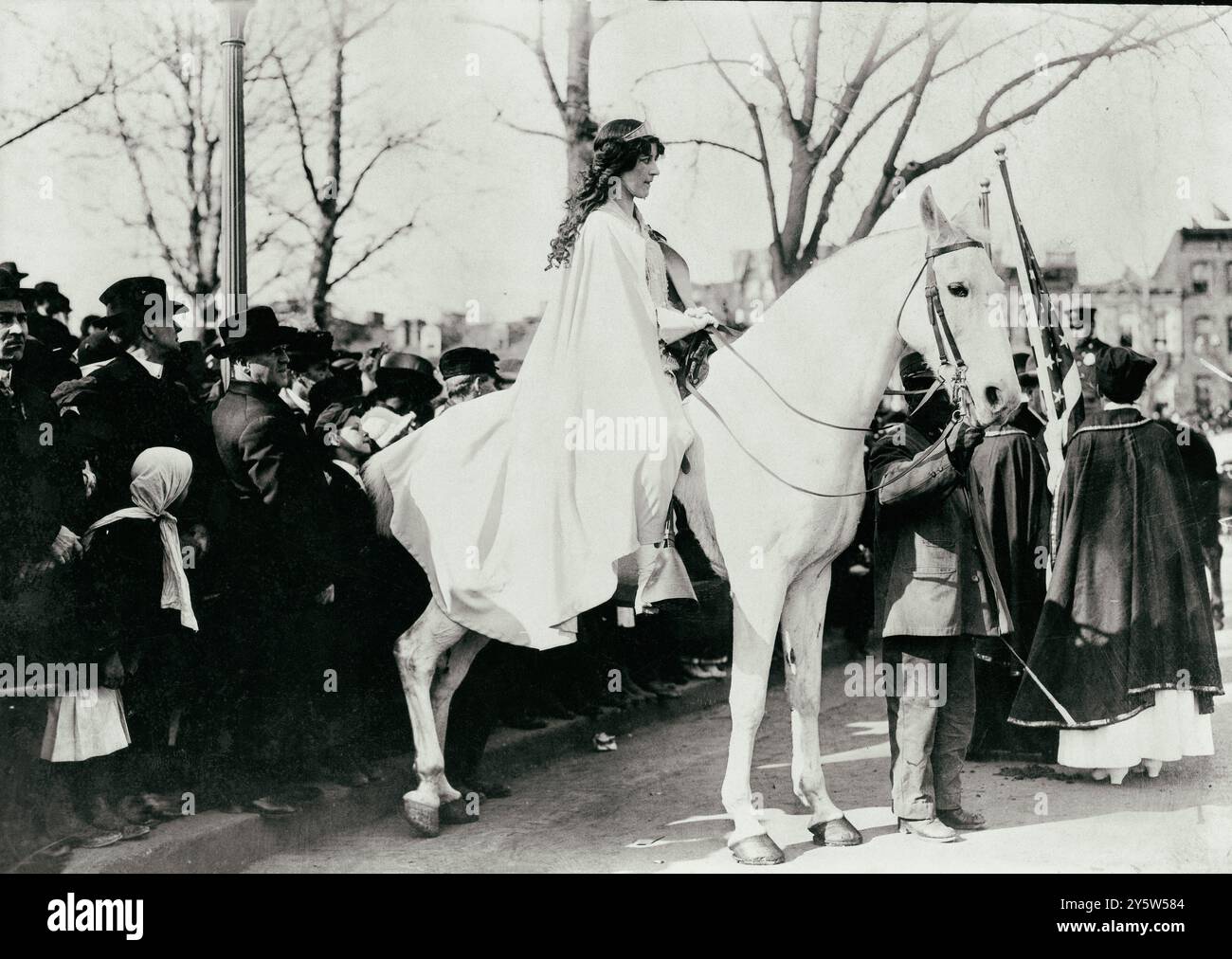 Inez Milholland Boissevain, con indosso un mantello bianco, seduto a cavallo bianco alla parata della National American Woman Suffrage Association, 3 marzo 1913, Washington, D.C. Inez Milholland Boissevain (1886–1916) è stata una suffragista, avvocato e attivista per la pace americana. Dai suoi giorni di college al Vassar College, ha fatto una campagna aggressiva per i diritti delle donne come principale questione di un'agenda socialista di ampio respiro. Nel 1913, guidò la drammatica processione del suffragio femminile a cavallo prima dell'inaugurazione del presidente Woodrow Wilson come araldo simbolico. Era anche un avvocato del lavoro e un corpo di guerra Foto Stock