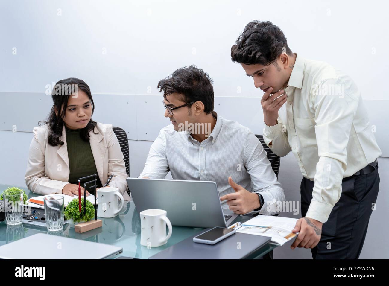 Un team di professionisti è intensamente impegnato in una discussione su un progetto importante in un ambiente di ufficio moderno è concentrato e collaborativo, altamente Foto Stock