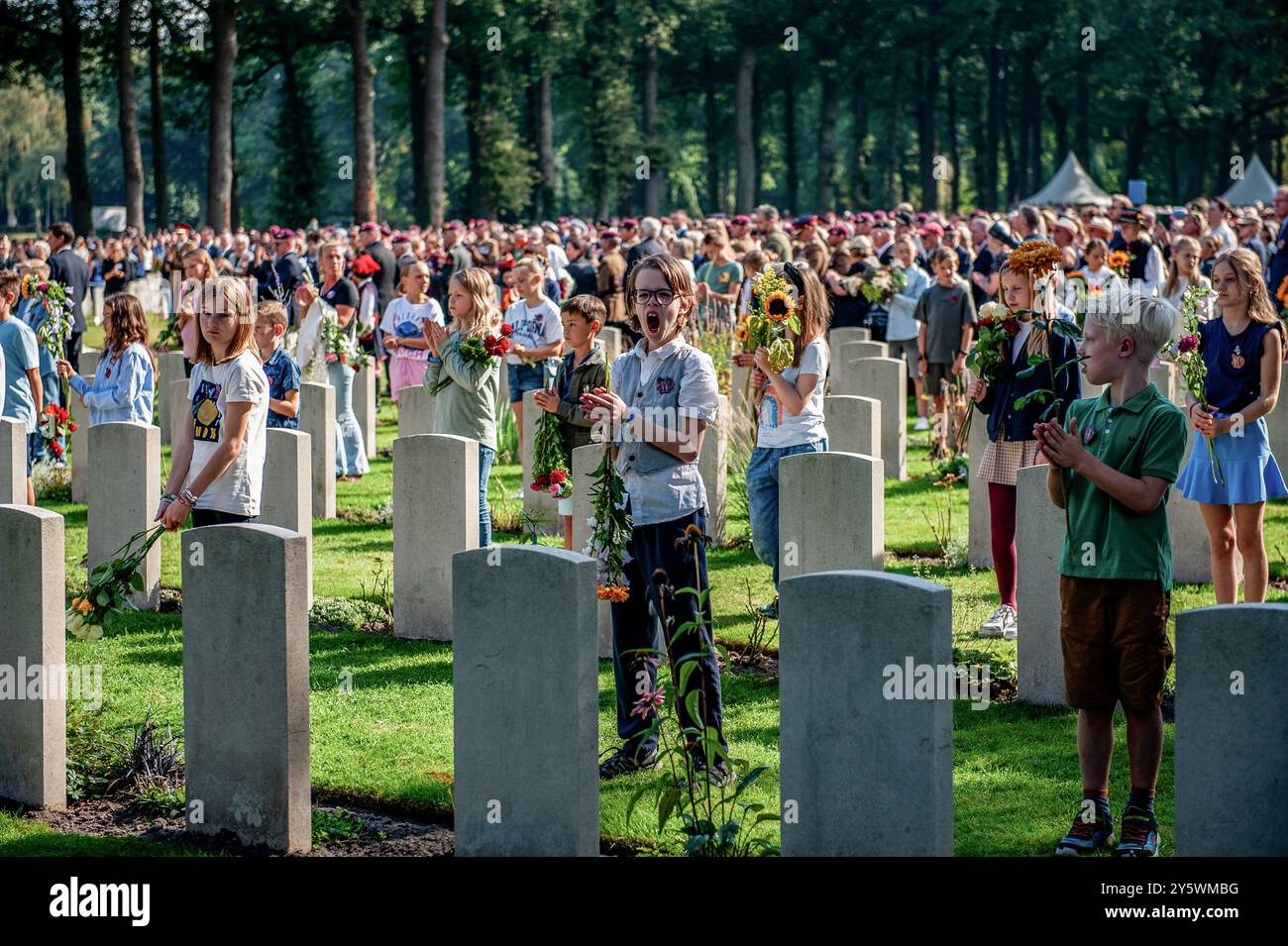 Oosterbeek, Paesi Bassi. 22 settembre 2024. Un ragazzo sbadiglia mentre tiene i fiori al cimitero di guerra di Arnhem Oosterbeek. Al cimitero di guerra di Arnhem Oosterbeek furono sepolti più di 1750 soldati alleati. Come parte delle commemorazioni per il 80 ° anniversario dell'operazione Market Garden, un servizio commemorativo si è tenuto alla presenza dei veterani della seconda guerra mondiale, Anne, Princess Royal, e suo marito il vice ammiraglio Sir Timothy Laurence. Credito: SOPA Images Limited/Alamy Live News Foto Stock