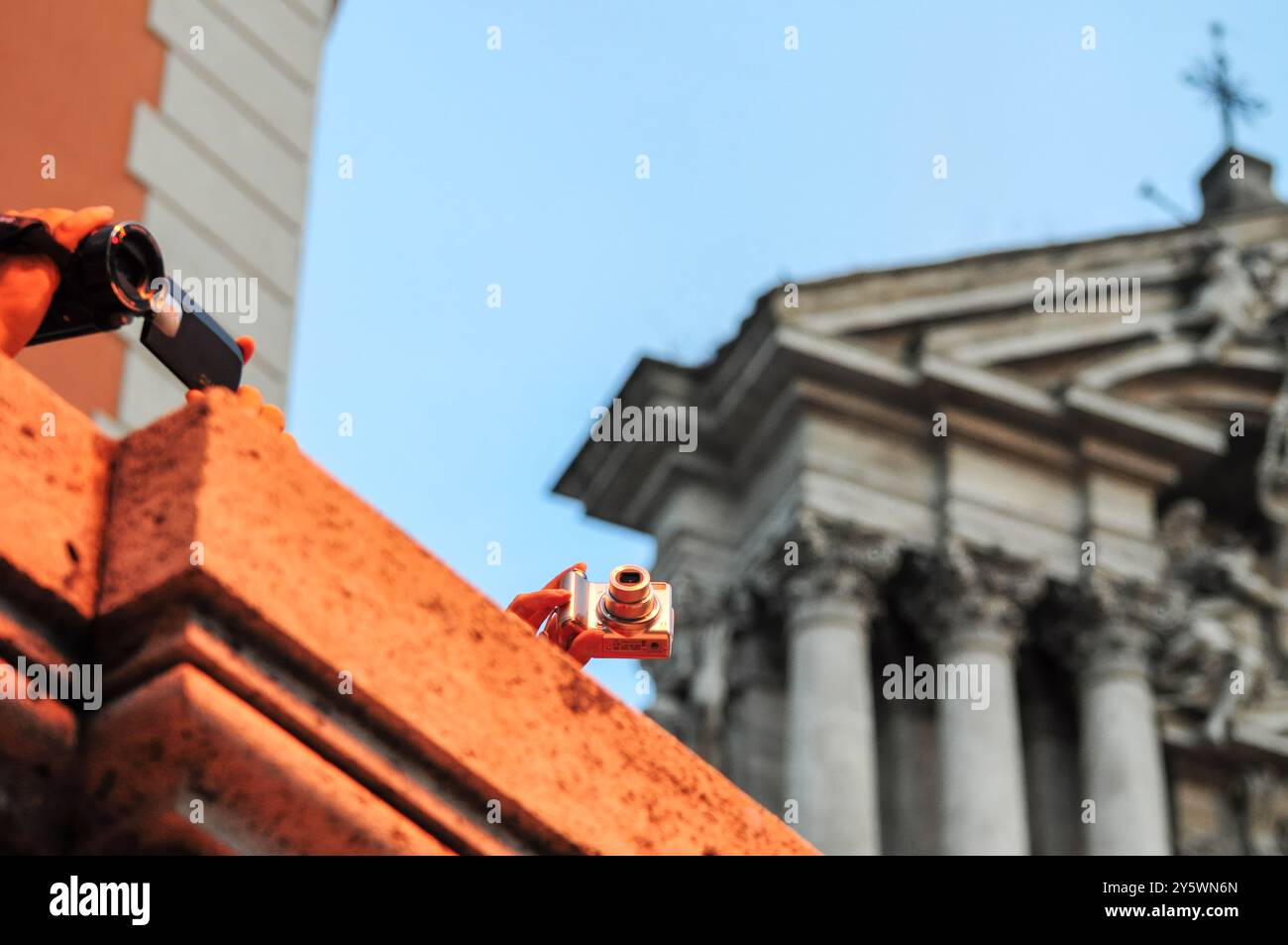 I turisti fotografano la storica architettura romana durante l'ora d'oro Foto Stock