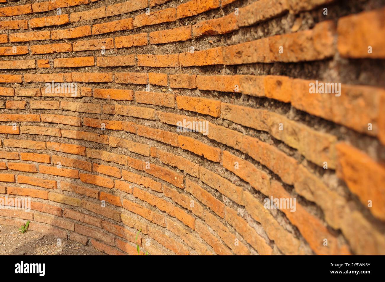 Primo piano sull'antico muro di mattoni, linee curve, architettura storica Foto Stock