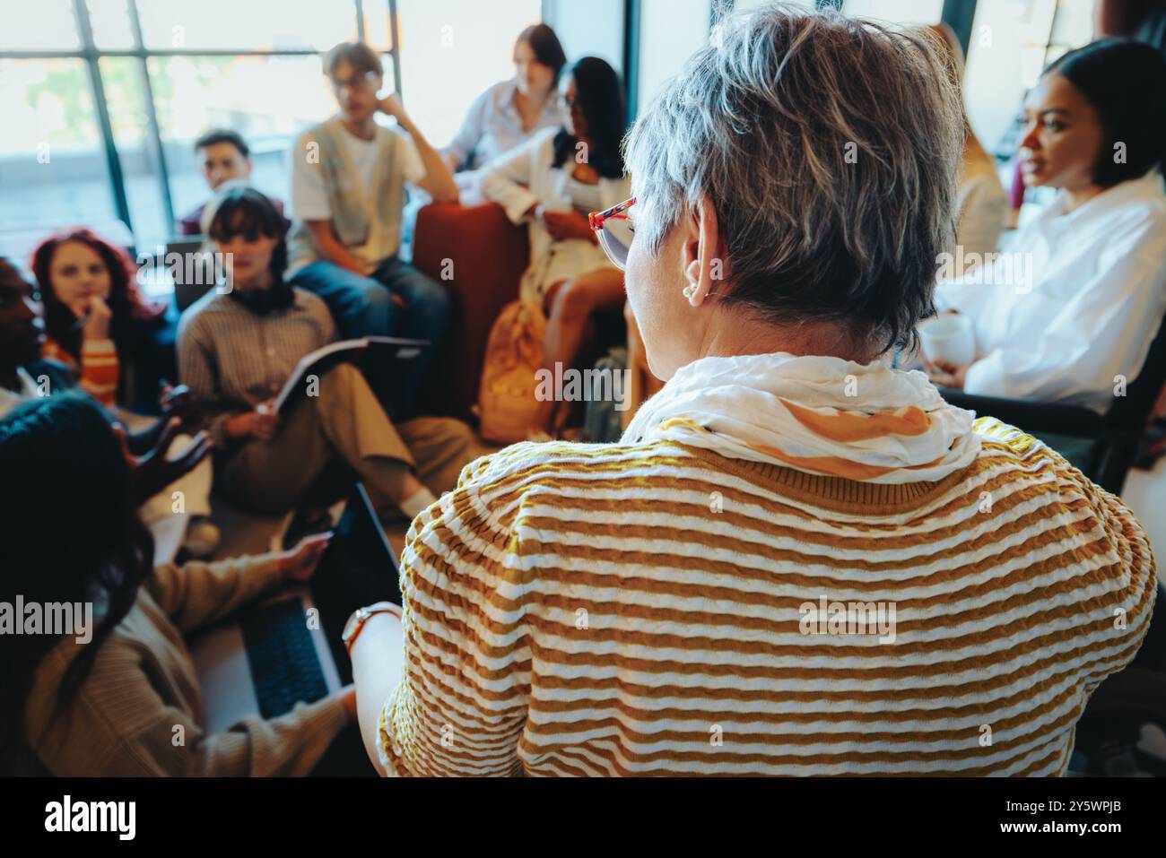 Un insegnante che coinvolge gli studenti in un ambiente informale, incoraggiando un dialogo aperto e una partecipazione attiva. Foto Stock