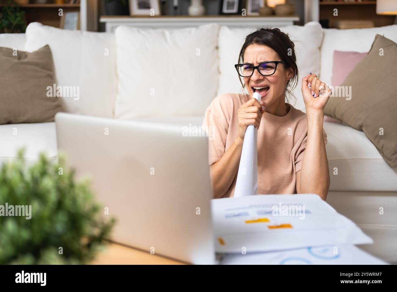 Giovane donna d'affari che lavora a casa in ufficio seduto sul pavimento del suo appartamento, lavora ai calcoli finanziari del computer portatile. Freelanc femmina Foto Stock