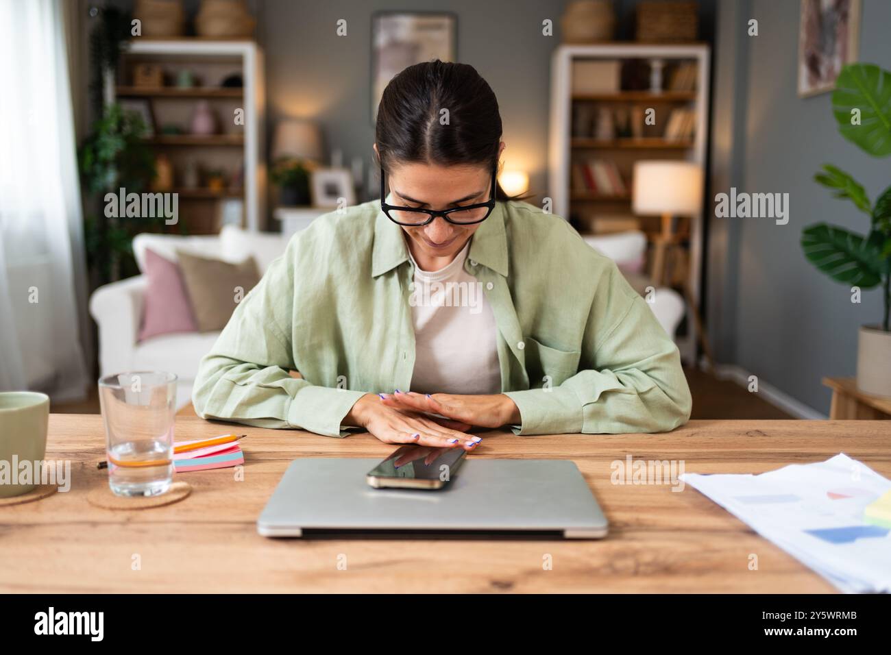Dipendente serio e premuroso seduto a un tavolo con un notebook nell'ufficio domestico, pensando ai problemi aziendali, al progetto, alla visione futura della carriera, sentendo dubbi Foto Stock