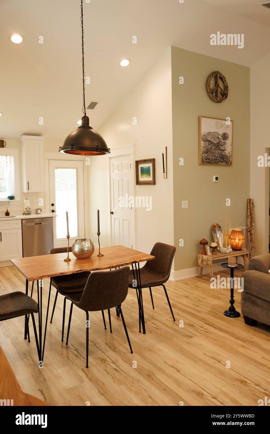 Moderna sala da pranzo con tavolo in legno, sedie grigie e lampada a sospensione decorativa, Florida, USA Foto Stock