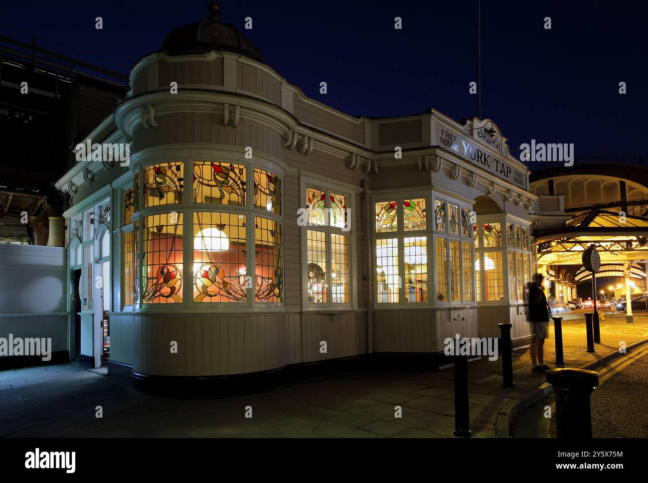 Lo York Tap, un pub incantevole vicino alla stazione di York con incredibili vetrate colorate in stile art nouveau, che sembrano particolarmente gloriose dopo il tramonto. Foto Stock