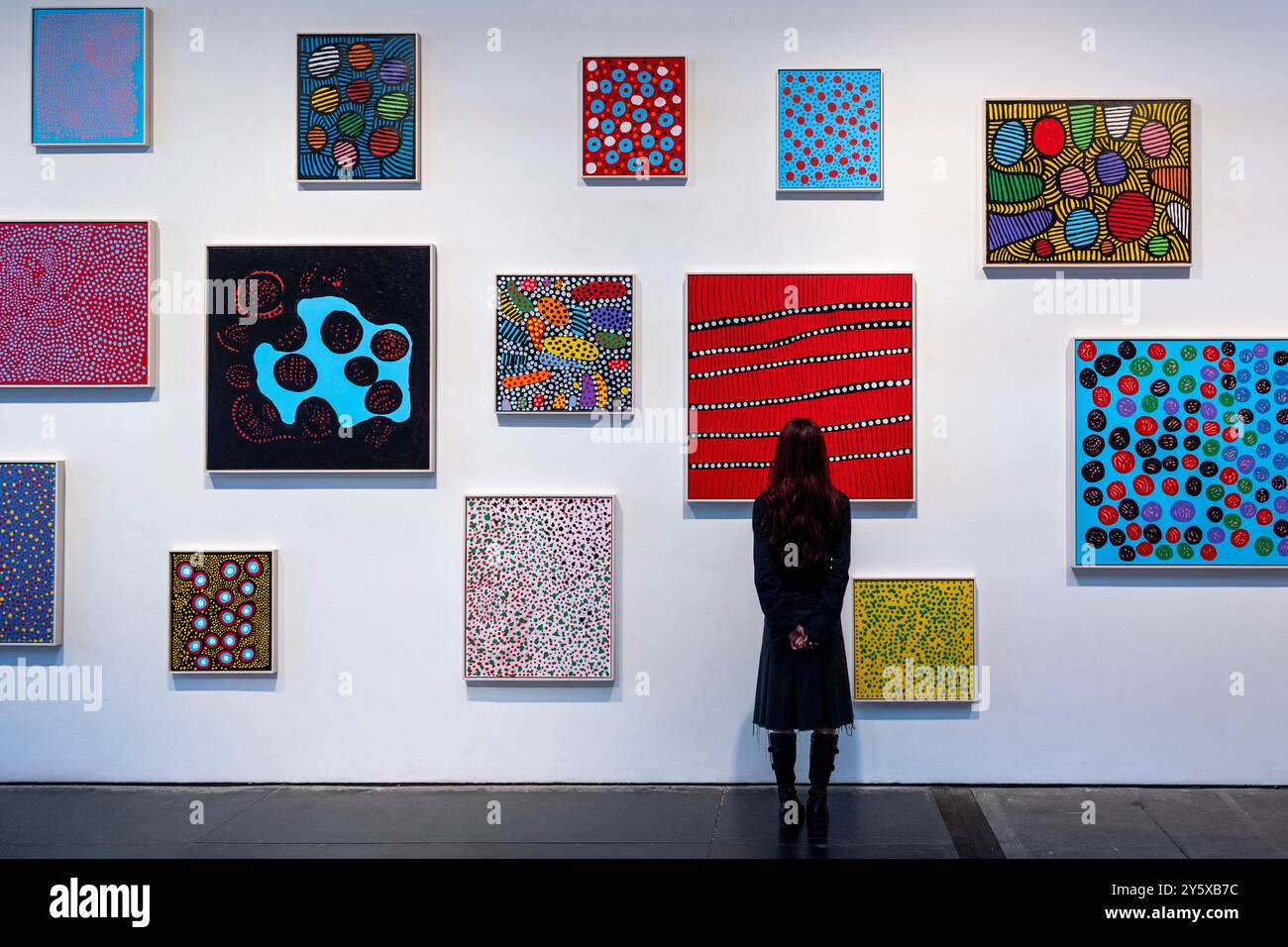Londra, Regno Unito. 23 settembre 2024. Un membro dello staff con nuovi dipinti in anteprima a "Every Day i Pray for Love", la quattordicesima mostra personale di Yayoi Kusama con la galleria Victoria Miro, che presenta l'ultima serie di dipinti e sculture dell'artista e una nuova stanza a specchio dell'Infinito chiamata "Beauty described by a Spherical Heart" (bellezza descritta da un cuore sferico). La mostra si svolge presso la galleria Wharf Road di Victoria Miro dal 25 settembre al 2 novembre 2024. Crediti: Stephen Chung / Alamy Live News Foto Stock