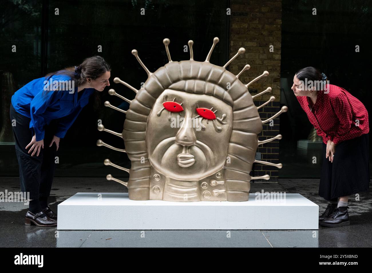 Londra, Regno Unito. 23 settembre 2024. Membri dello staff con "Women", 2024, in anteprima di "Every Day i Pray for Love", la quattordicesima mostra personale di Yayoi Kusama con la galleria Victoria Miro, che presenta l'ultima serie di dipinti e sculture dell'artista e una nuova stanza a specchio dell'Infinito intitolata "Beauty described by a Spherical Heart". La mostra si svolge presso la galleria Wharf Road di Victoria Miro dal 25 settembre al 2 novembre 2024. Crediti: Stephen Chung / Alamy Live News Foto Stock
