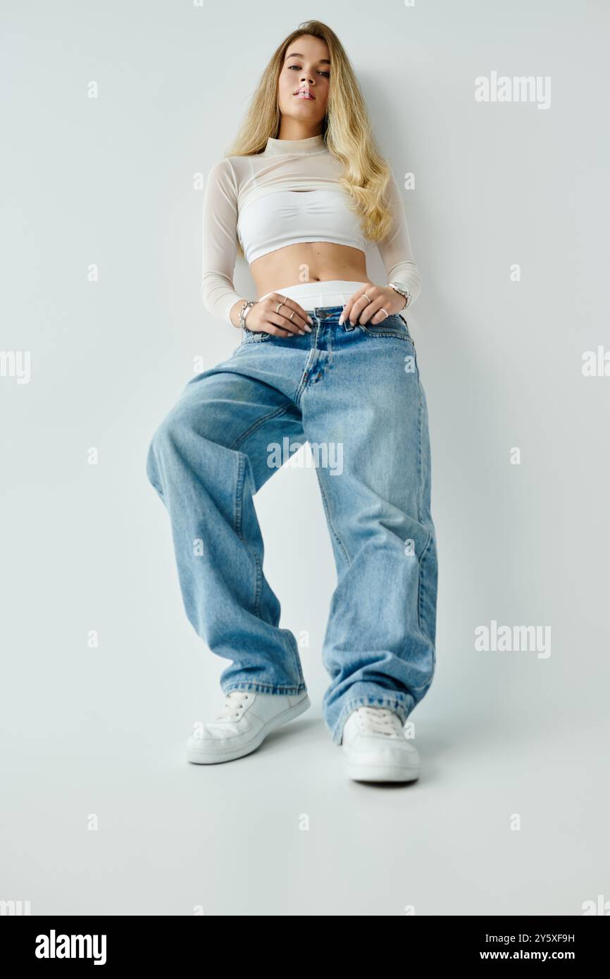 Alta, una giovane donna sfoggia il suo stile casual con fiducia in un outfit alla moda. Foto Stock
