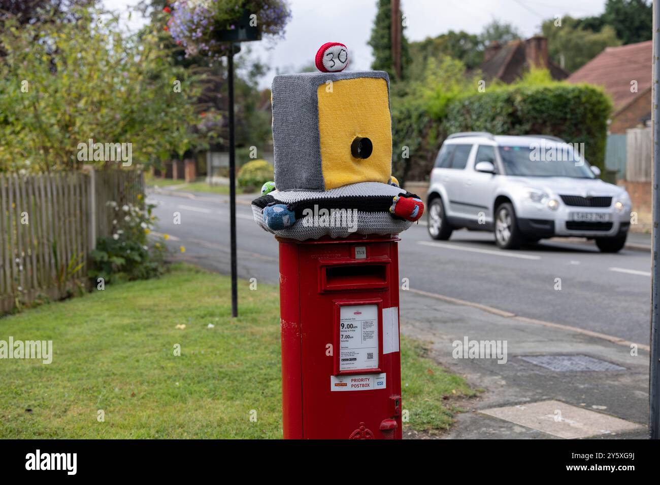 Autovelox lavorato a maglia con coperchio della scatola postale, decorazioni all'uncinetto destinate a scoraggiare i conducenti dall'andare in velocità lungo una strada residenziale nell'Hampshire, Regno Unito Foto Stock