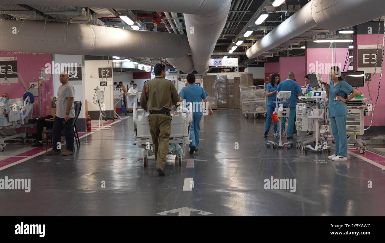 HAIFA, ISRAELE - 22 SETTEMBRE: Soldati israeliani e personale ospedaliero spingono i letti dei pazienti nel parcheggio sotterraneo del Rambam Medical Center dopo che la direzione ha spostato i suoi reparti e i pazienti sotterranei alla luce della situazione della sicurezza e dopo gli attacchi missilistici dal Libano il 22 settembre 2024 ad Haifa, Israele. Foto Stock