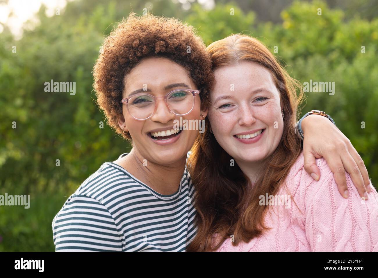 Abbracciando e sorridendo, le donne le amiche si divertono insieme nella natura Foto Stock