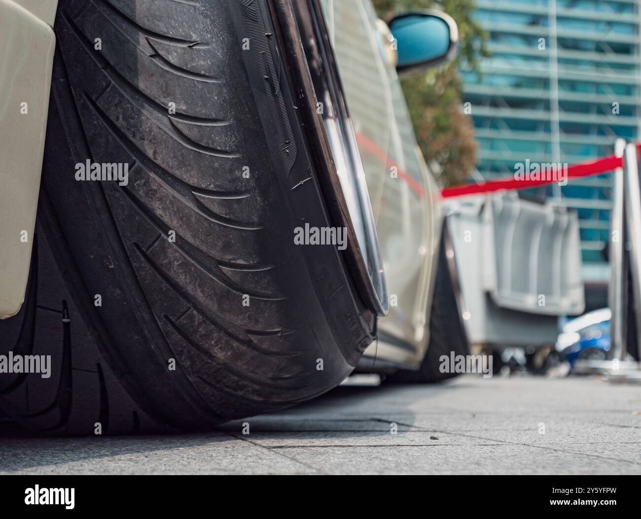 Pneumatico a basso profilo su un'auto modificata parcheggiata in occasione di un evento cittadino che mostra la cultura automobilistica durante il giorno Foto Stock