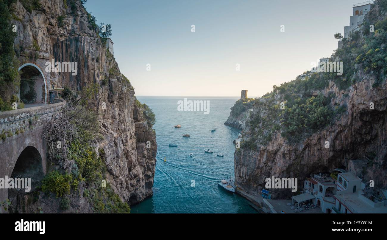 Baia della spiaggia di Furore sulla Costiera Amalfitana al tramonto e tunnel stradale sulla sinistra, vista panoramica. Regione Campania, Italia, Europa Foto Stock